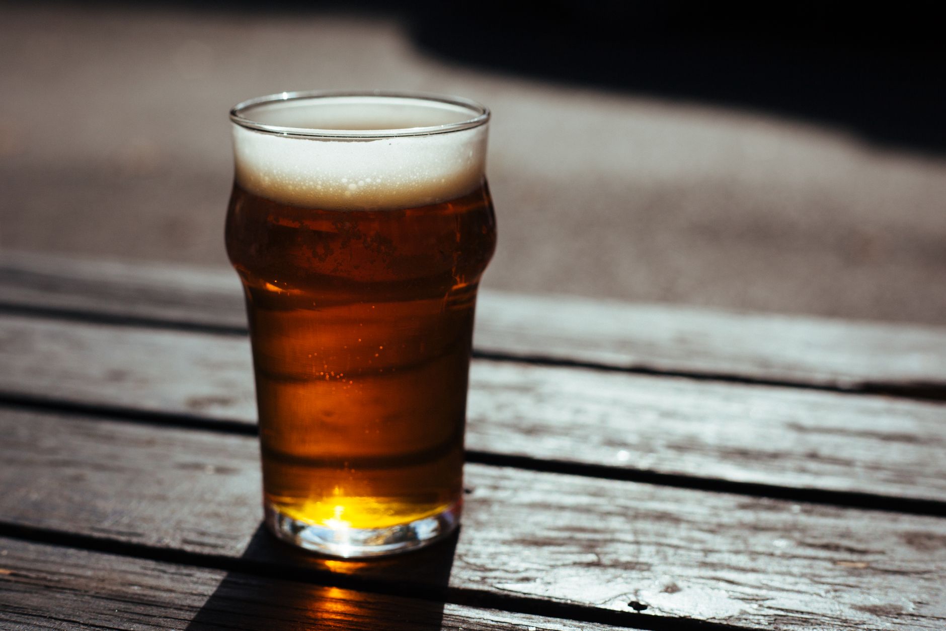 Kühles Bier auf Holztisch in der Sonne